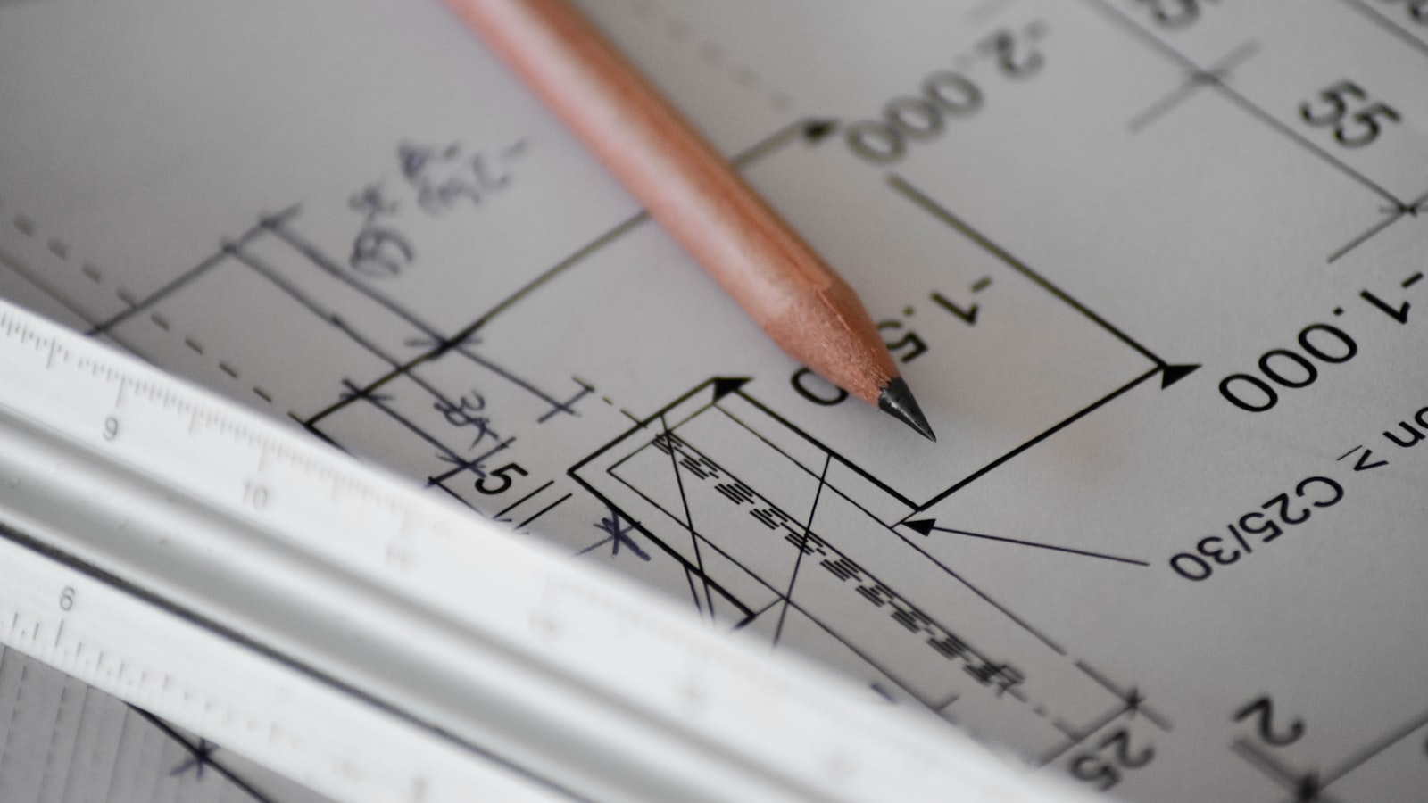 Two coworkers reviewing notes together at a table, one pointing at a shared document.