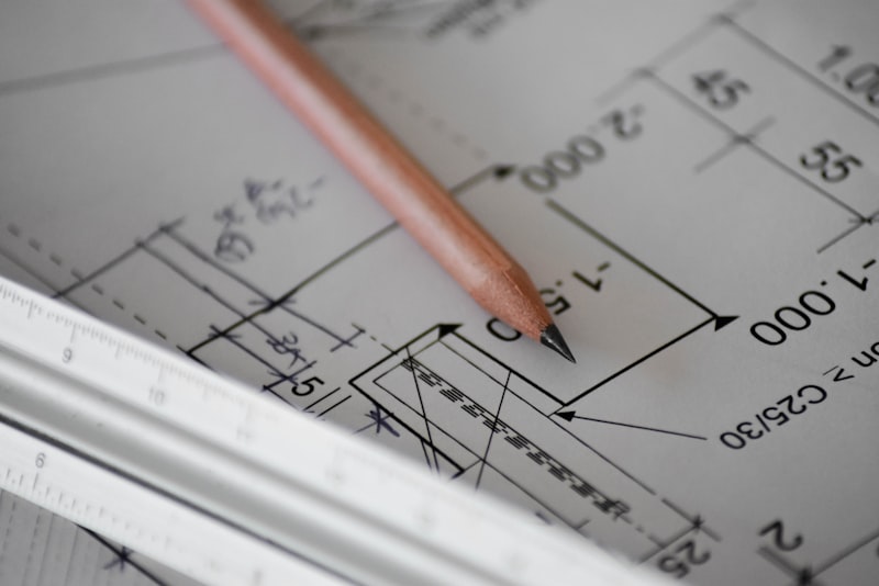 Two coworkers reviewing notes together at a table, one pointing at a shared document.