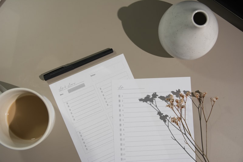 A person working at a tidy home desk with a laptop and a cup of coffee.