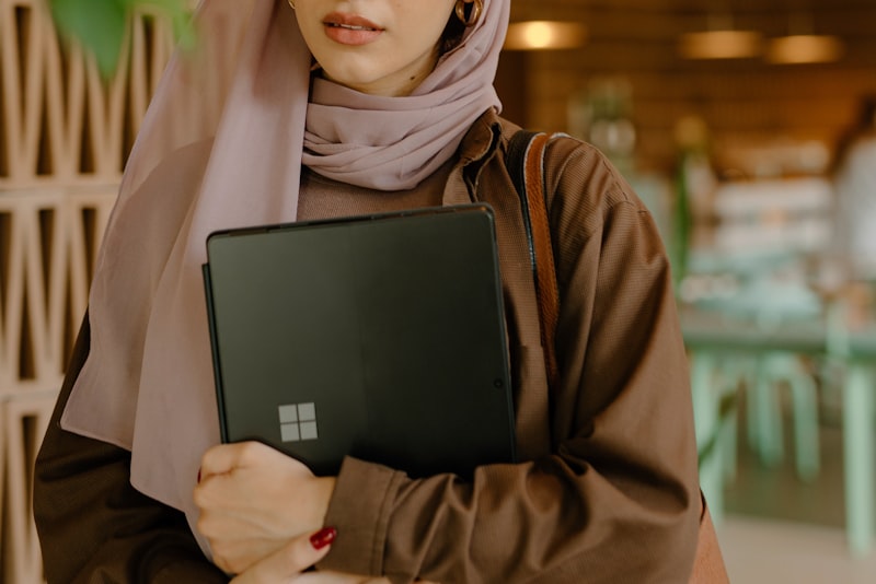 A person sitting at a desk reviewing notes on a laptop before an interview